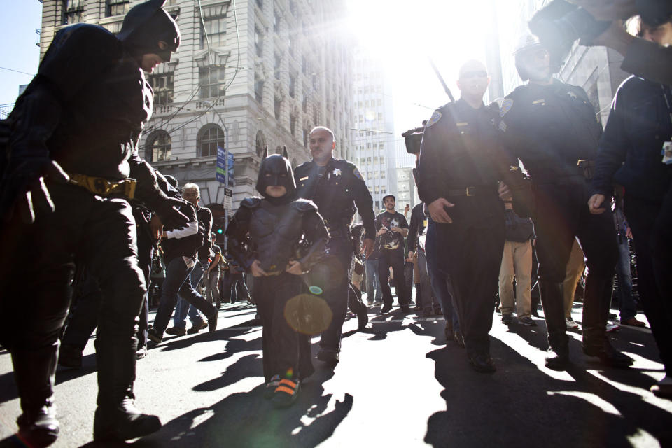 miles wearing a batman costume with a crowd around him