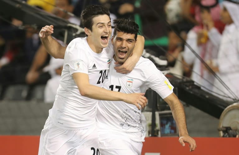 Iran's Mehdi Taremi (R) celebrates with teammate Sardar Azmoun (L) after scoring a goal against Qatar during their World Cup 2018 Asia qualifying football match in Doha on March 23, 2017