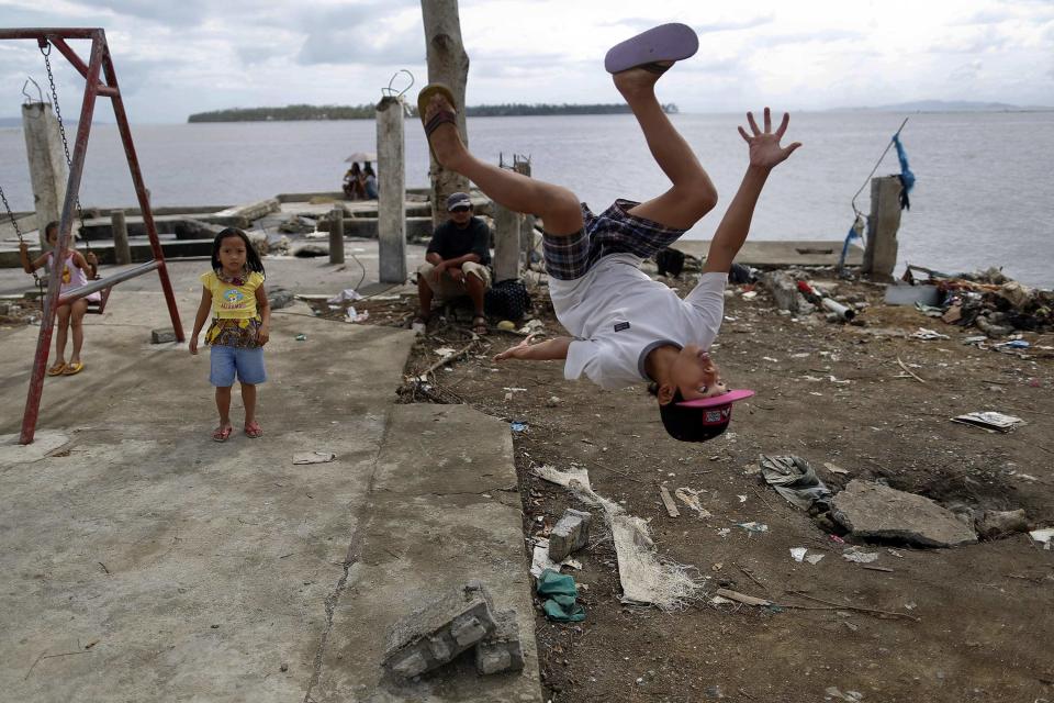 John Dave Galang, a survivor of Typhoon Haiyan, shows his acrobatic skills at a devastated area of Basey, north of Tacloban