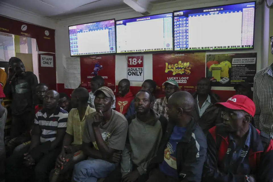 Customers watch screens in a sports betting shop in the low-income Kibera neighborhood of the capital Nairobi, Kenya, Monday, Dec. 5, 2022. (AP Photo/Brian Inganga)