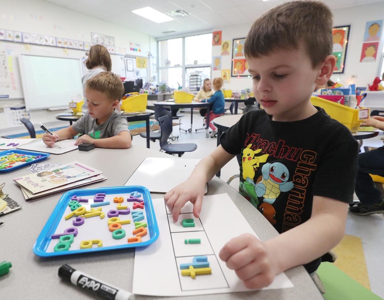 Liam Brooks places the consonant blend "th" in a box as he spells out the word thin as Owen Galea writes the word thin during a small group  reading lesson at McDowell Early Learning School in Hudson.