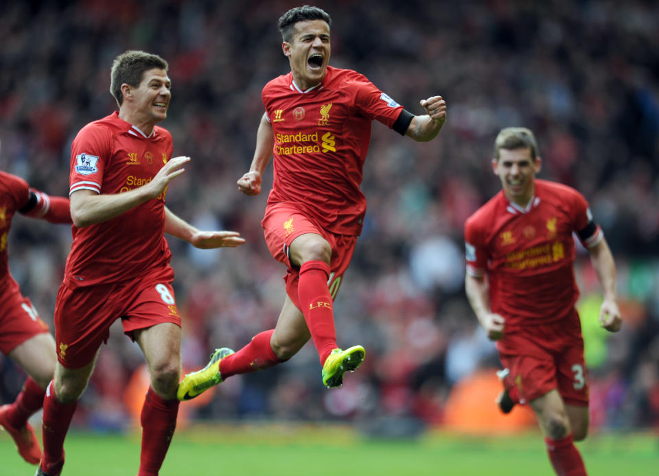 Liverpool's Philippe Coutinho, centre, celebrates with teammate Steven Gerrard, left, after he scored the third goal of the game for his side during their English Premier League soccer match against Manchester City at Anfield in Liverpool, England, Sunday April. 13, 2014. (AP Photo/Clint Hughes)