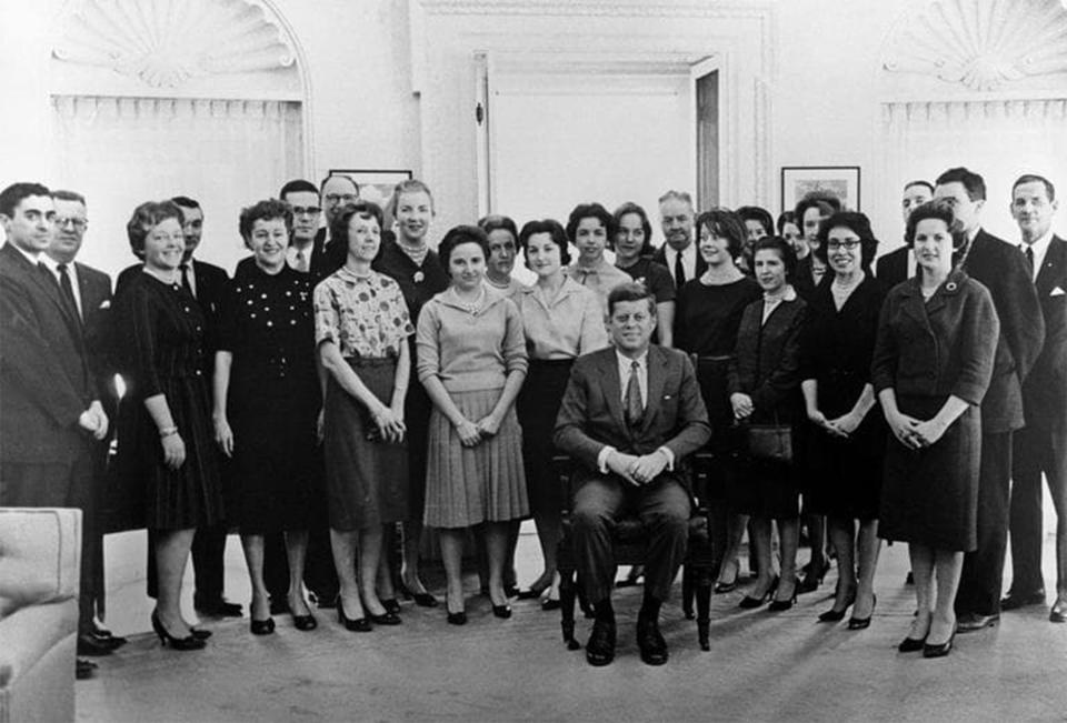 President John F. Kennedy sits in a chair bought for him by his staff, including Montgomery native Jean Price Lewis (rear, left behind Kennedy).