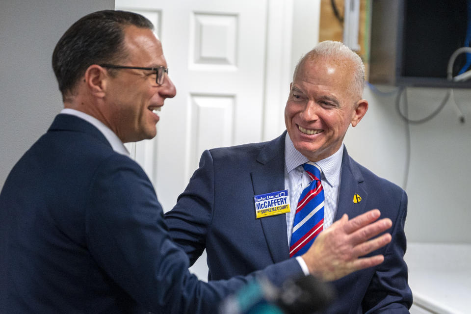 Democrat Dan McCaffery, right, who is running for a seat on the state Supreme Court, greets Pennsylvania Gov. Josh Shapiro as he arrives for a Democratic campaign rally in Newtown, Pa., Tuesday, Nov. 7, 2023. (Tom Gralish/The Philadelphia Inquirer via AP)