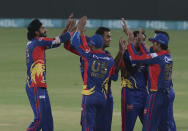 Karachi Kings pacer Umaid Asif, left, celebrates with teammates after taking the wicket of Qalandars batsman Tamim Iqbal during the final of Pakistan Super League T20 cricket match at National Stadium in Karachi, Pakistan, Tuesday, Nov. 17, 2020. (AP Photo/Fareed Khan)