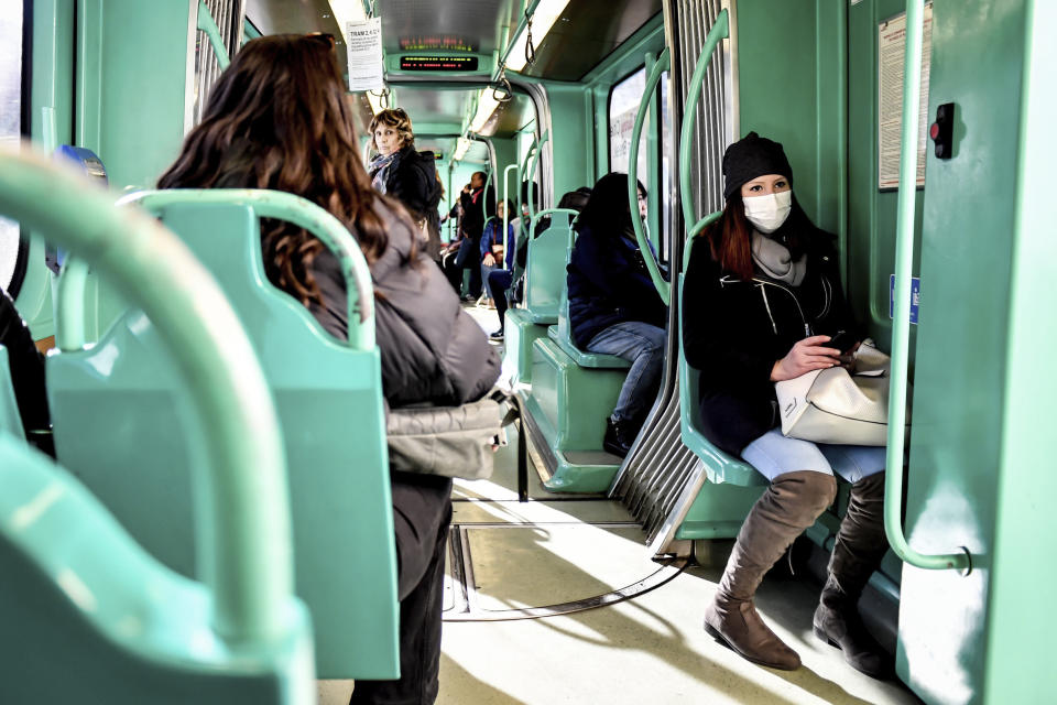 A woman wearing a sanitary mask sits in a streetcar in Milan, Italy, Monday, Feb. 24, 2020. At least 190 people in Italy’s north have tested positive for the COVID-19 virus and four people have died, including an 84-year-old man who died overnight in Bergamo, the Lombardy regional government reported. (Claudio Furlan/Lapresse via AP)