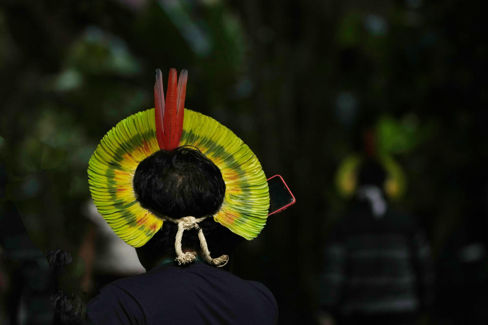 An Indigenous person wearing a headdress speaks on his cell phone in Park dos Igarapes where Indigenous people gather for the Amazon Summit in Belem, Brazil, Monday, Aug. 7, 2023. Belem will host the Amazon Summit, a meeting by the nations that are part of the Amazon Cooperation Treaty: Brazil, Bolivia, Colombia, Guyana, Ecuador, Peru, Suriname, Venezuela and French Guiana. (AP Photo/Eraldo Peres)