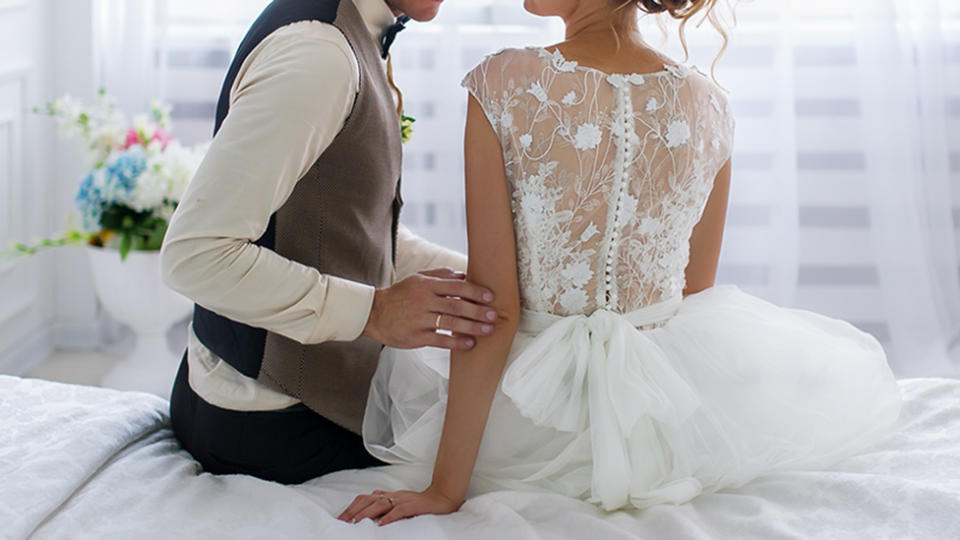 Bride and groom on a bed on their wedding night