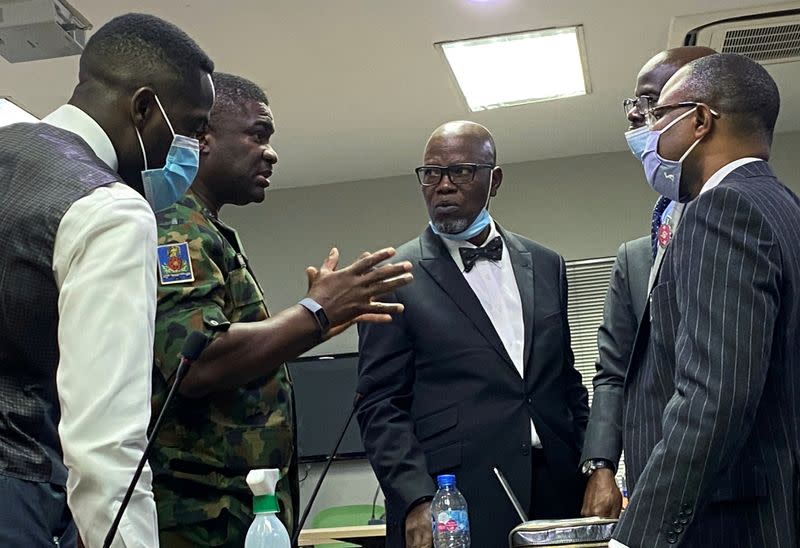 Brigadier General Ahmed Taiwo speaks with the counsel for the Nigerian Army, Akinlolu Kehinde and others during a judicial panel in Lagos