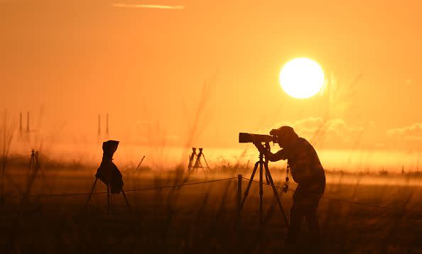 CAPE CANAVERAL, FL - NOVEMBER 15: Ground fog covers the Kennedy Space Center Press Site as a photographer lines up his shot toward the Artemis 1 moon rocket and the Orion spacecraft poised on Launch Pad 39B  November 15, 2022, as the countdown for the third launch attempt continues at the Kennedy Space Center in Cape Canaveral, Florida. NASA's Artemis 1 mission is the first test of the agency's deep space exploration systems sending the unmanned Orion spacecraft to orbit the moon several times and return back to earth. (Photo by Red Huber/Getty Images)