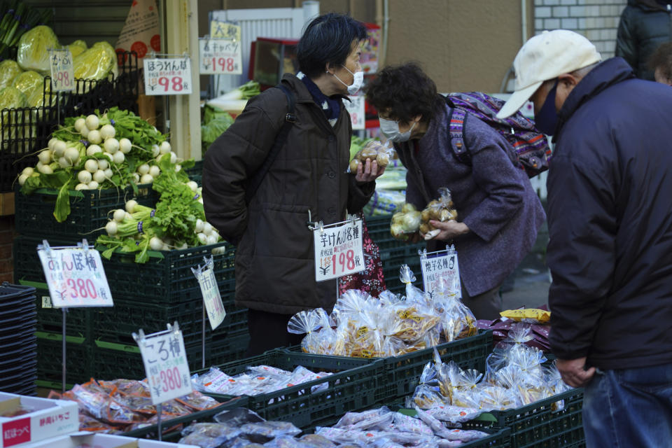 People wearing protective masks to help curb the spread of the coronavirus shop at a vegetable shop in Tokyo Thursday, Jan. 14, 2021. The Japanese capital confirmed more than 1500 new coronavirus cases on Thursday. (AP Photo/Eugene Hoshiko)