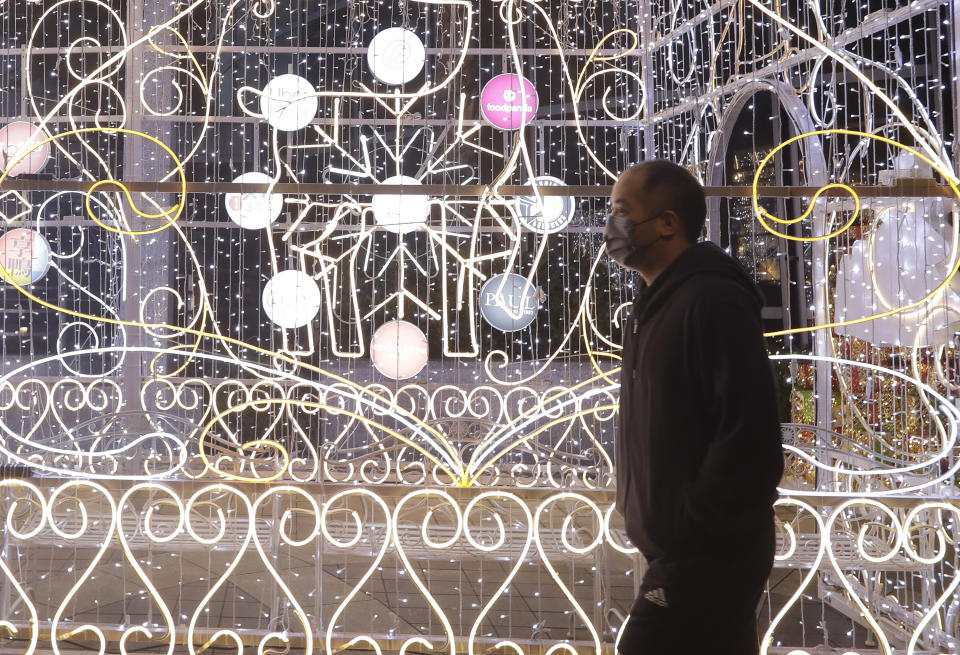 A man wearing face masks to protect against the spread of the coronavirus walks past Christmas decoration in Taipei, Taiwan, Thursday, Dec. 23, 2021. (AP Photo/Chiang Ying-ying)