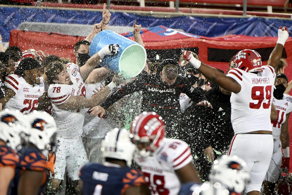 Louisiana-Lafayette coach Billy Napier is doused by offensive lineman Luke Junkunc (78) during the fourth quarter of the team's 31-24 win over UTSA in the First Responder Bowl NCAA college football game in Dallas, Saturday, Dec. 26, 2020. (AP Photo/Matt Strasen)