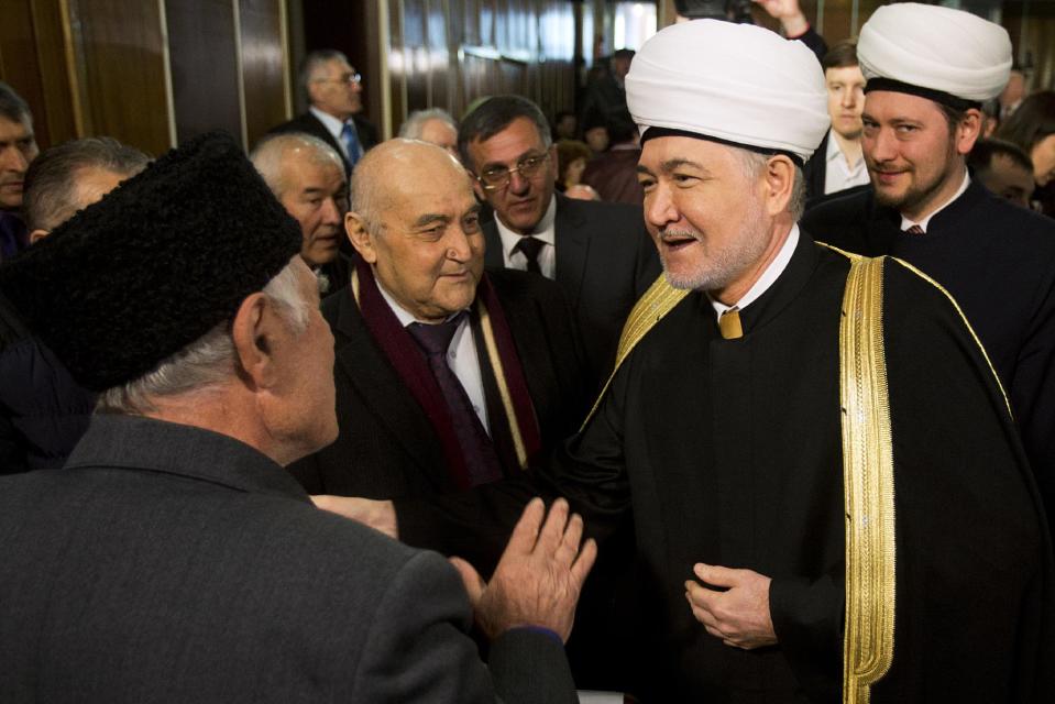 Crimean Tatars greet Russia's top Muslim Cleric Ravil Gainutdin, foreground right, during the Crimean Tatar Qurultay, a religious congress, in Bakhchysarai, Crimea, Saturday, March 29, 2014. The Crimean Tatar Qurultay, a religious congress will determine whether the Tatars will accept Russian citizenship and the political system that comes with it, or remain Ukrainian citizens on Russian soil. (AP Photo/Pavel Golovkin)