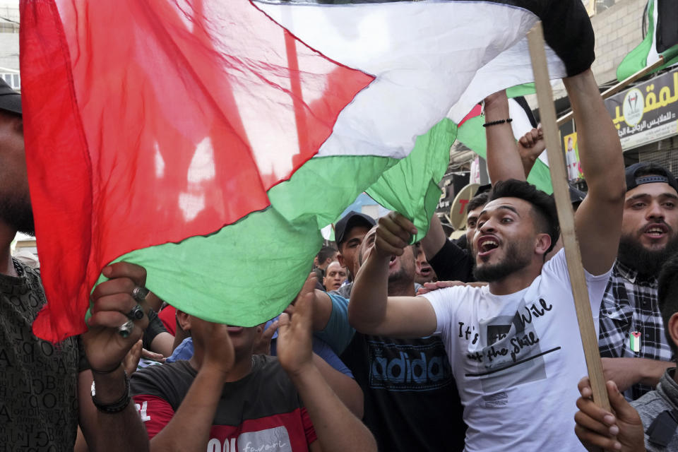 Hamas supporters chant Islamic slogans while waving Palestinian flags during a protest against the Israeli flags march to mark Jerusalem Day, an Israeli holiday celebrating the capture of the Old City of Jerusalem during the 1967 Mideast war, in the Jebaliya refugee camp, northern Gaza Strip, Sunday, May 29, 2022. (AP Photo/Adel Hana)