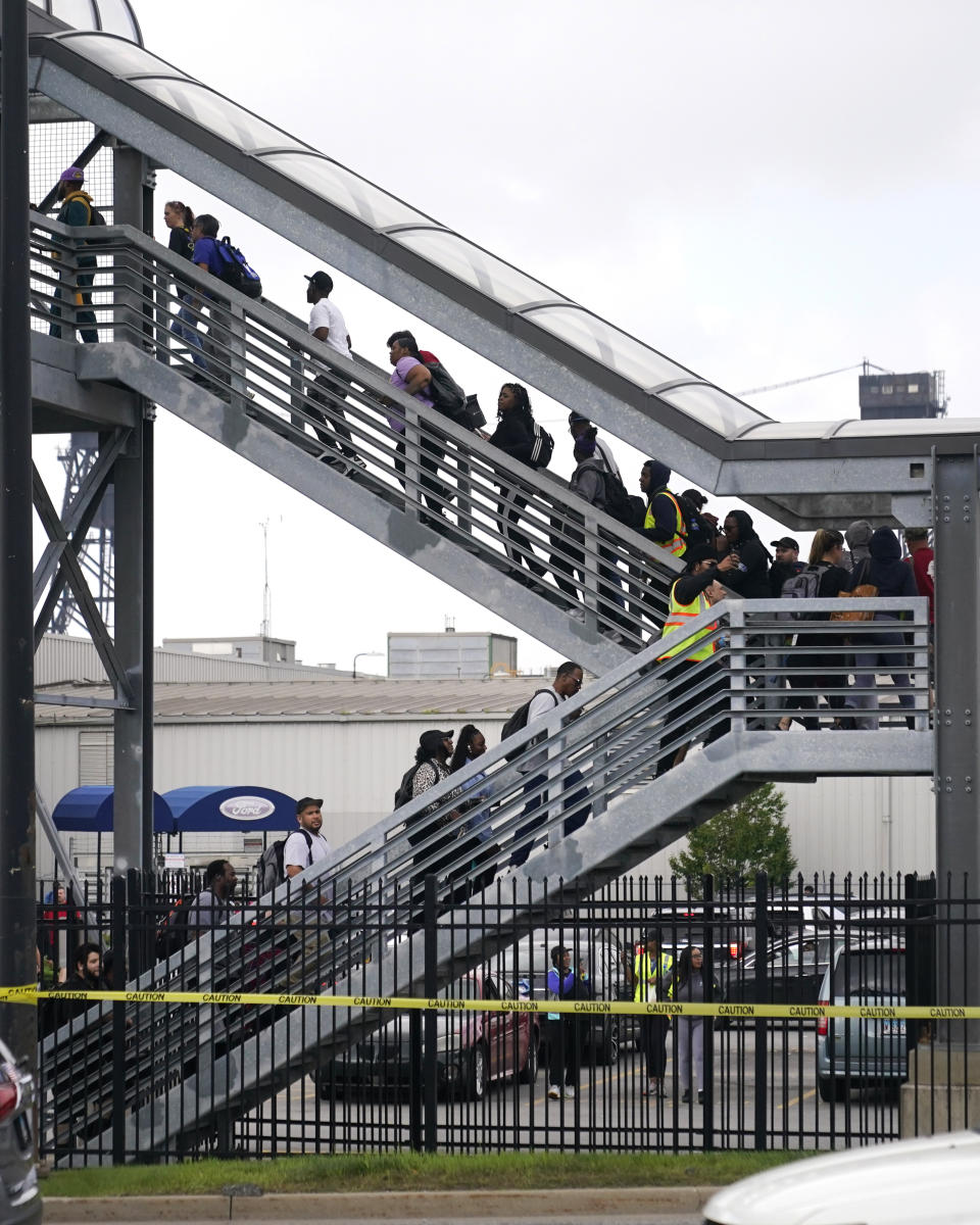 Members of the United Auto Worker Union walk out of the Chicago Ford Assembly Plant and across a pedestrian bridge to a parking lot Friday, Sept. 29, 2023, in Chicago. (AP Photo/Charles Rex Arbogast)