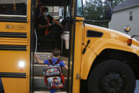 Paul Adamus, 7, climbs the stairs of a bus before the fist day of school on Monday, Aug. 3, 2020, in Dallas, Ga. Adamus is among tens of thousands of students in Georgia and across the nation who were set to resume in-person school Monday for the first time since March. (AP Photo/Brynn Anderson)