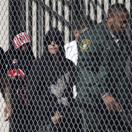 Teen pop star Justin Bieber, in a black hooded sweatshirt with a bird design, departs a Miami-Dade County jail in Miami, Florida January 23, 2014. REUTERS/Andrew Innerarity