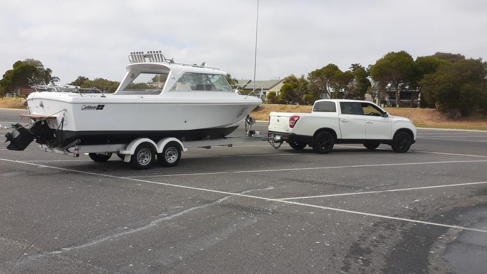 A EV ute pictured towing boat. 