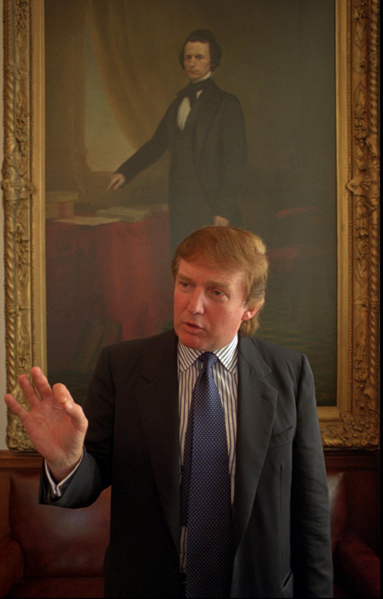 Donald Trump speaks to a reporter at the New York Court of Appeals while awaiting arguments in a real estate appraisal case in Albany, N.Y. on Sept. 3, 1996.  Trump says he owns land involved in the case and wanted to see the case argued in person.