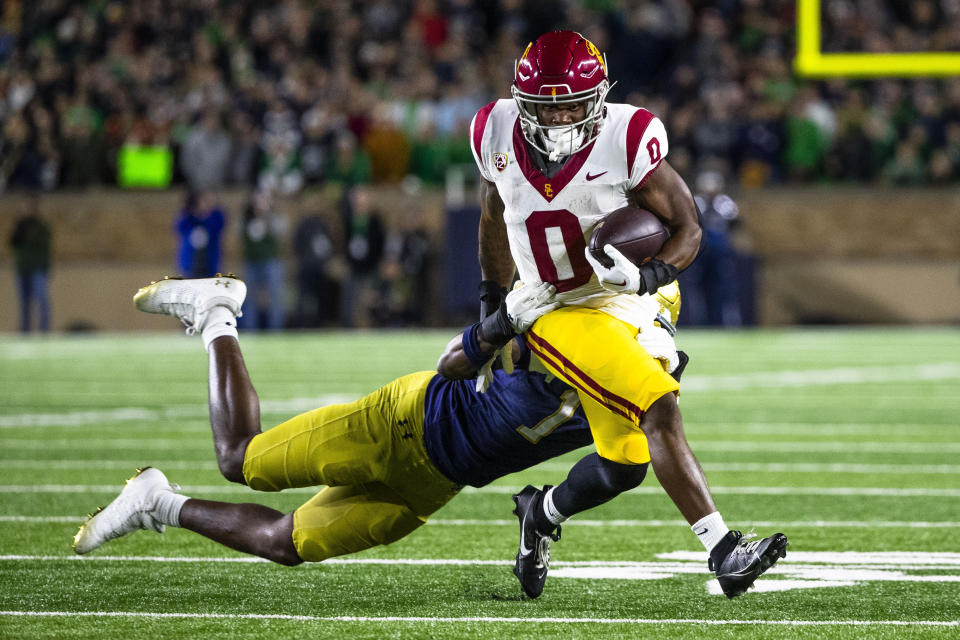 Southern California running back MarShawn Lloyd (0) gets past Notre Dame defensive lineman Javontae Jean-Baptiste (1) during the first half an NCAA college football game Saturday, Oct. 14, 2023, in South Bend, Ind. (AP Photo/Michael Caterina)