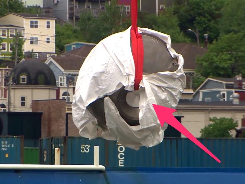 An annotated picture shows footage of the debris being winched off the rescue ship shows the partially covered front viewport.