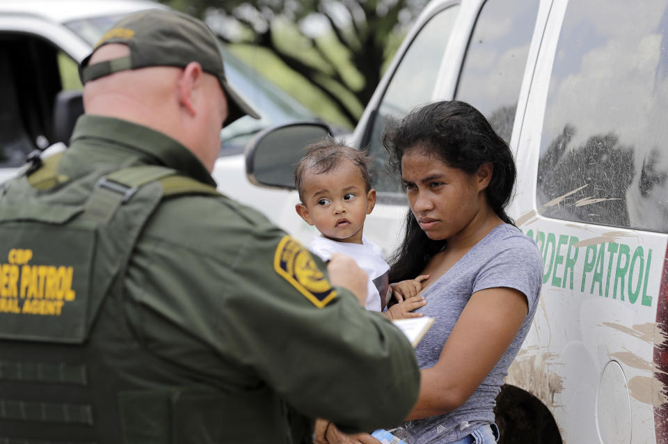 FILE - A mother migrating from Honduras holds her 1-year-old child as surrendering to U.S. Border Patrol agents after illegally crossing the border, near McAllen, Texas, Monday, June 25, 2018. Texas state police officers separated migrant families along the border with Mexico by detaining fathers on trespassing charges and turning over mothers and children to federal officials, the state Department of Public Safety said Thursday, Aug. 3, 2023. (AP Photo/David J. Phillip, File)