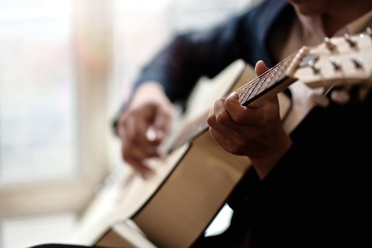 Closeup of man playing guitar