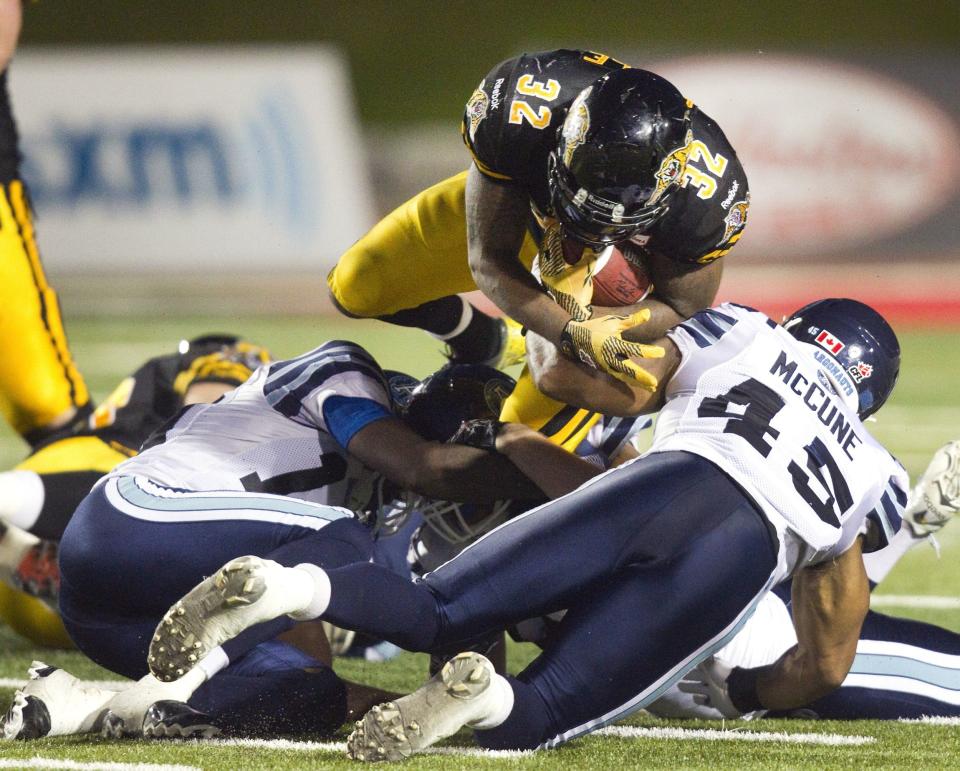 Tiger-Cats Gable dives over Argonauts McCune for a first down in the second half of their CFL game in Guelph