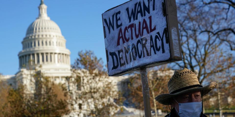 Protester David Barrows carries a sign during a rally to press Congress to pass voting rights protections and the "Build Back Better Act," Monday, Dec. 13, 2021, in Washington.