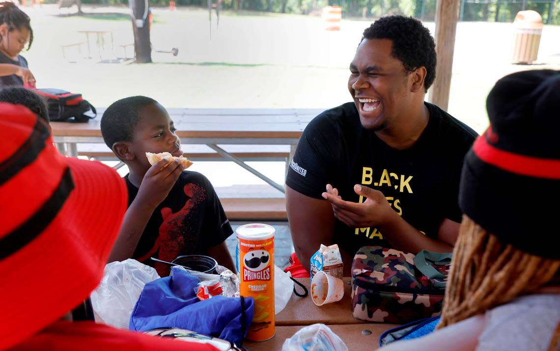 N.C. State offensive lineman Tim McKay laughs with Raleigh Parks and Recreation camper Redmond Graves, 8, while hanging out with him Wednesday, June 22, 2022. As part of the Wolfpack’s ‘D Leary Delivers’ campaign, N.C. State quarterback Devin Leary along with offensive linemen McKay, Bryson Speas and Derrick Eason brought a SnoCone truck to two Raleigh camps, hung out with the campers and then made snow cones for them. Ethan Hyman/ehyman@newsobserver.com