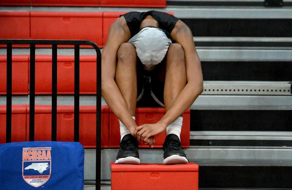 A member of the Ardrey Kell basketball team sits dejectedly in the stands following the team’s last-second loss to Millbrook in the boys 4A NCHSAA championship game at Wheatmore High School in Trinity, NC on Saturday, March 6, 2021. Millbrook defeated Ardrey Kell 67-65 in overtime.