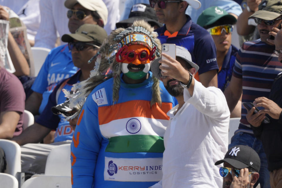 India cricket fans take photos on a smart phone on the fourth day of the ICC World Test Championship Final between India and Australia at The Oval cricket ground in London, Saturday, June 10, 2023. (AP Photo/Kirsty Wigglesworth)