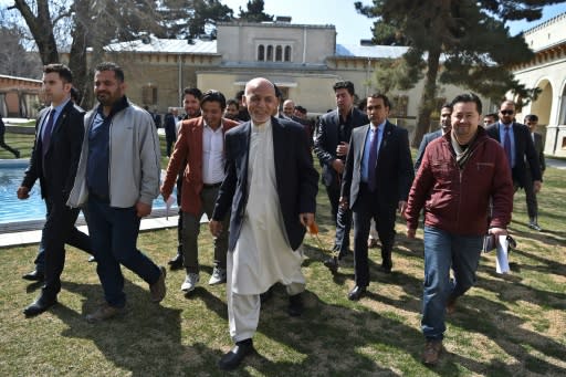 Afghan President Ashraf Ghani (C), walking with journalists after a press conference at the presidential palace, said he would not commit to a clause in the US-Taliban deal calling for a massive prisoner exchange