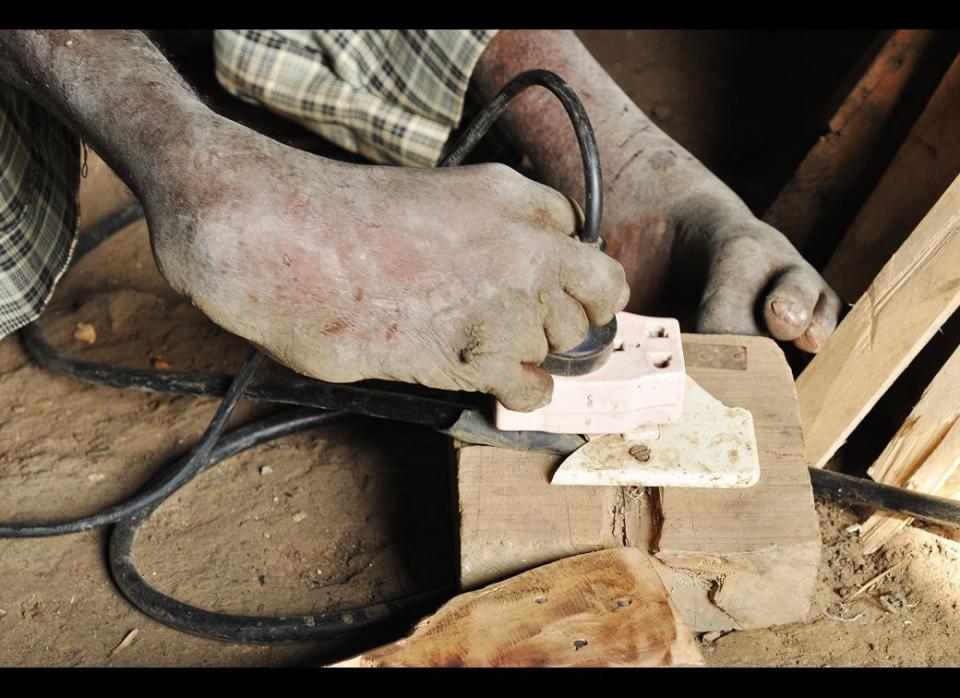 In this photo,  Sintayehu Tishale, 42, plugs in his electric drill with his feet on July 9, 2011 in his workshop in Welete Suk, on the edge of Addis Ababa, Ethiopia.    