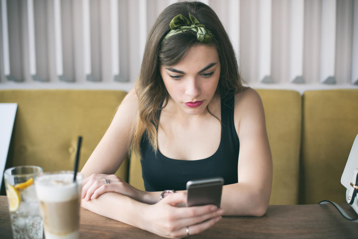 Negative emotion. Woman receiving upsetting message on mobile phone