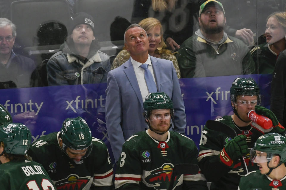 Minnesota Wild head coach Dean Evason, center top, checks the scoreboard during an NHL hockey game against the Ottawa Senators in the third period Sunday, Dec. 18, 2022, in St. Paul, Minn. (AP Photo/Craig Lassig)