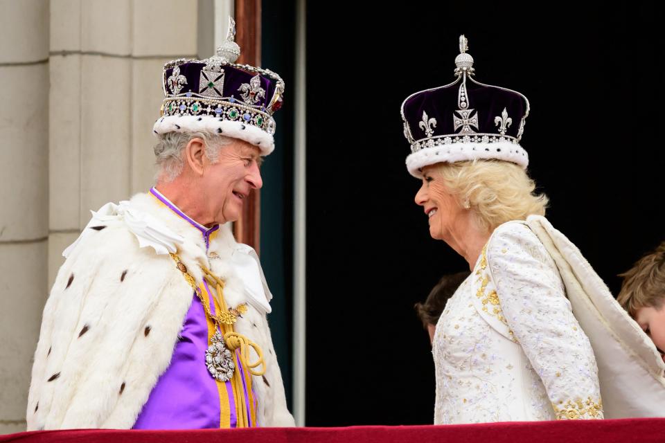TOPSHOT - Britain's King Charles III (L) looks at Queen Camilla as they stand on the Buckingham Palace balcony, in London, following their coronations, on May 6, 2023. - The set-piece coronation is the first in Britain in 70 years, and only the second in history to be televised. Charles will be the 40th reigning monarch to be crowned at the central London church since King William I in 1066. Outside the UK, he is also king of 14 other Commonwealth countries, including Australia, Canada and New Zealand. Camilla, his second wife, will be crowned queen alongside him, and be known as Queen Camilla after the ceremony. (Photo by Leon Neal / POOL / AFP) (Photo by LEON NEAL/POOL/AFP via Getty Images)
