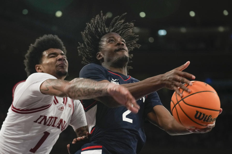 Indiana's Kel'el Ware, left, tries to guard UConn's Tristen Newton during the second half of an NCAA college basketball game, Sunday, Nov. 19, 2023, in New York. (AP Photo/Seth Wenig)