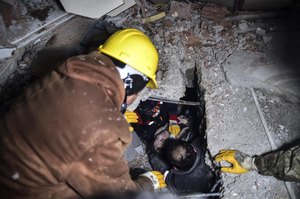 Equipos de emergencia rescatan a una mujer de entre los escombros de un edificio que se vino abajo tras un sismo, en Elbistan, Kahramanmaras, en el sur de Turquía, el 7 de febrero de 2023. (Ismail Coskun/IHA vía AP)