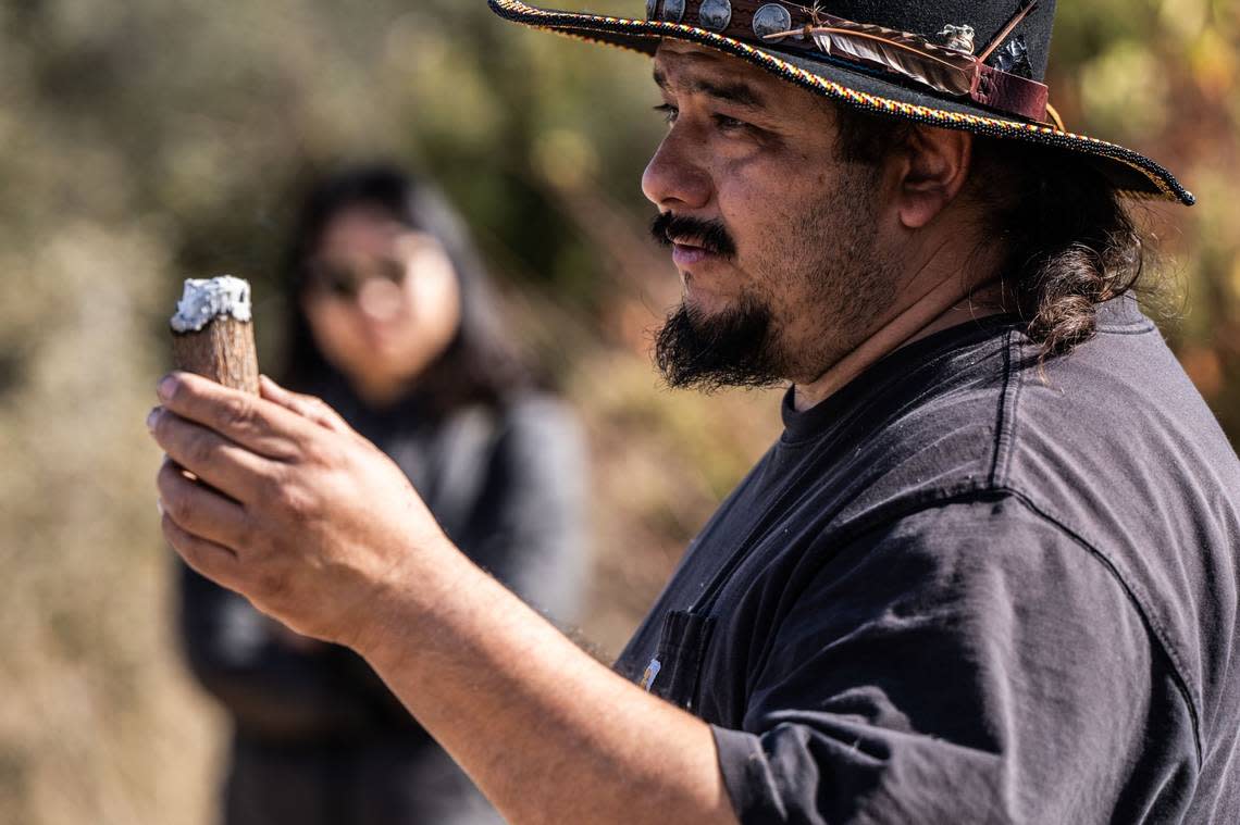 Danny Manning, a local firefighter and part of the Native American Maidu community, demonstrates Friday how his ancestors kept fires going by keeping an ember inside a piece of wood during the cultural burn. Hector Amezcua/hamezcua@sacbee.com