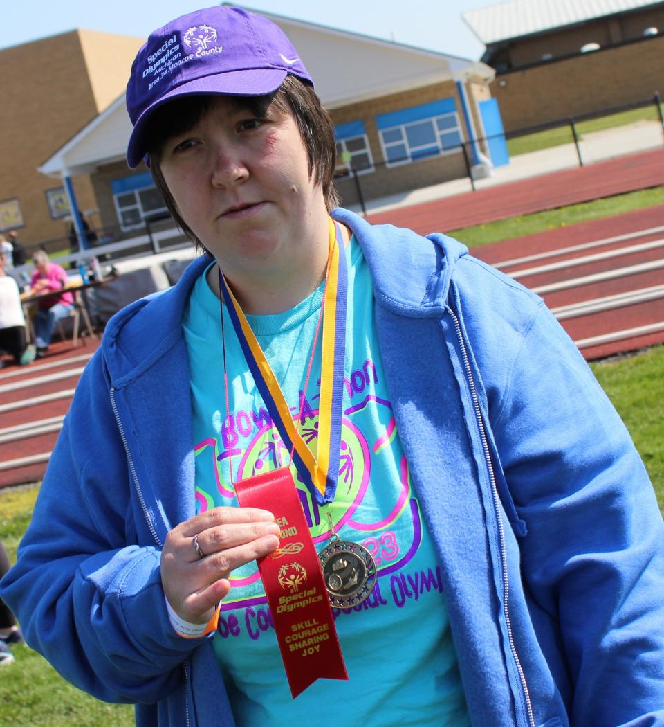 Karly Kodelman, 37, proudly displays the second place ribbon she won in the women's softball throw at this year's Monroe County Special Olympics. Kodelman competed in the 22 and older age group.