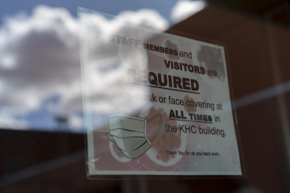 FILE - In this April 18, 2020, file photo, a sign on a door warns people to wear face coverings at the Kayenta Health Center on the Navajo reservation in Kayenta, Ariz. Across the nation, Native American tribes are working to protect their oldest members from the coronavirus. The effort is about more than protecting lives. (AP Photo/Carolyn Kaster, File)