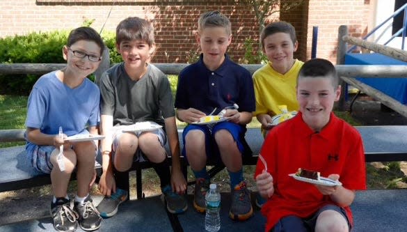 From left, current Natick High athletes Jack Sullivan (wrestling), Robert Farr (baseball), Dominic Crisafulli (swimming), Sean Fleming (basketball, track) and Pat Mulholland (basketball) eat slices of cake at Johnson School nearly a decade ago.