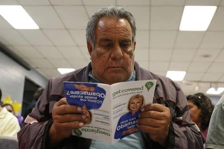 Jesus Dominguez, 63, who does not have health insurance, reads a pamphlet at a health insurance enrollment event in Cudahy, California March 27, 2014. REUTERS/Lucy Nicholson