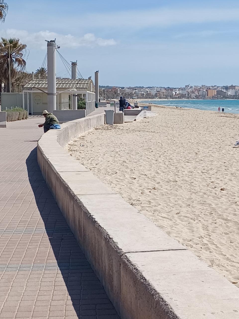 <span class="caption">Un vendeur ambulant attend les touristes sur la promenade balnéaire vide de S’Arenal. Photo T. Szpyrka, 04/2021.</span>