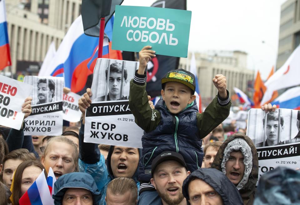 FILE - In this photo taken on Aug. 10, 2019, people with posters show portraits of detained protesters and a boy with a poster reads Lyubov Sobol react during a protest in Moscow, Russia. This summer's wave of opposition protests has pushed Sobol to the forefront of the Russian political scene. (AP Photo/Alexander Zemlianichenko, File)