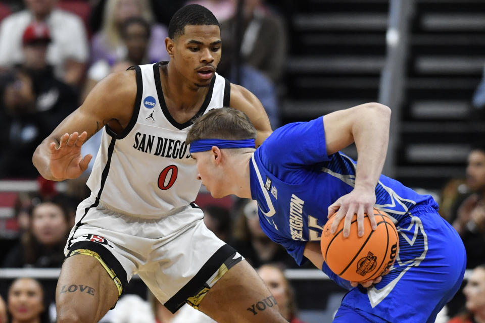 Creighton guard Baylor Scheierman (55) moves the ball against San Diego State forward Keshad Johnson (0) in the first half of a Elite 8 college basketball game in the South Regional of the NCAA Tournament, Sunday, March 26, 2023, in Louisville, Ky. (AP Photo/Timothy D. Easley)