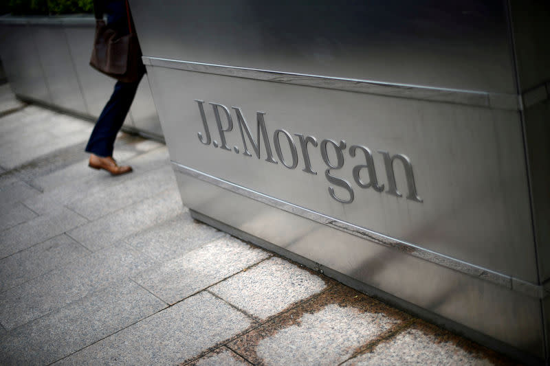 FILE PHOTO: A man walks into the JP Morgan headquarters at Canary Wharf in London May 11, 2012. REUTERS/Dylan Martinez/File Photo