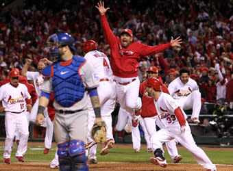 Texas catcher Mike Napoli walks off the field as members of the victorious Cardinals celebrate David Freese's 11th-inning home run